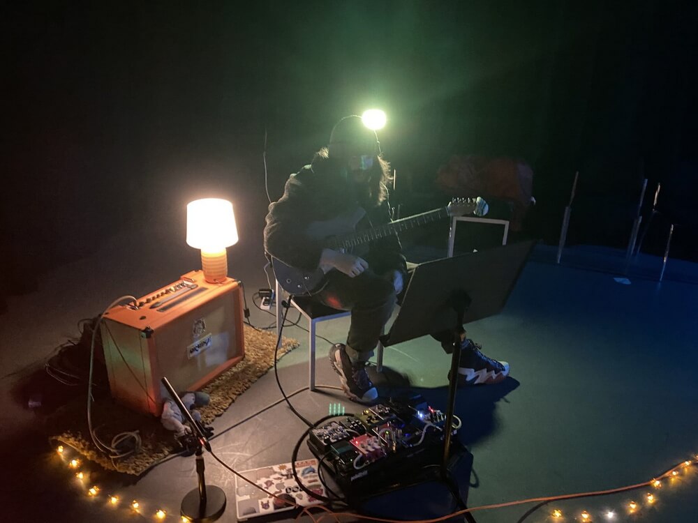 Elliot performing amid fairy lights and pedals